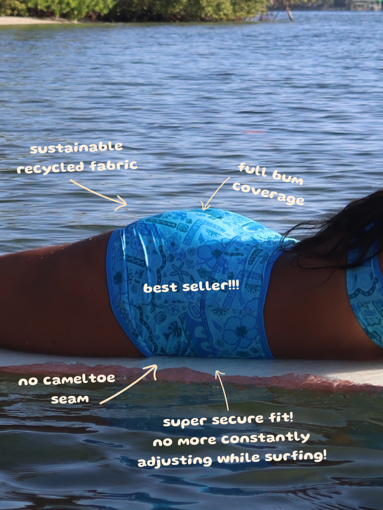 Person wearing blue swim bottoms with text highlighting features, standing in water.